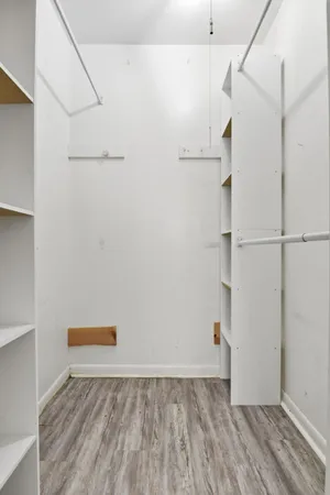 a view of walk in closet with clothes and shoes