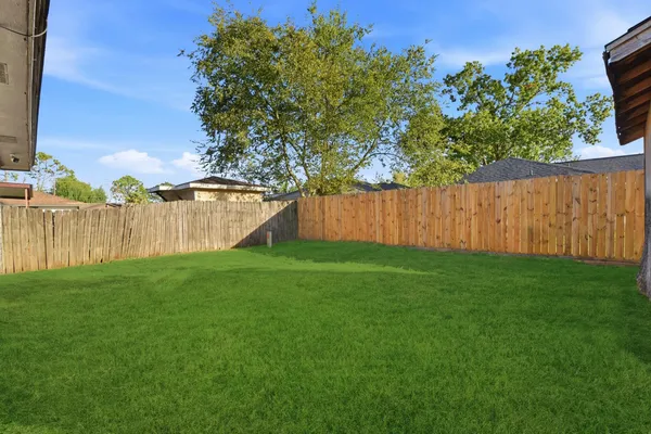 a view of backyard with wooden fence