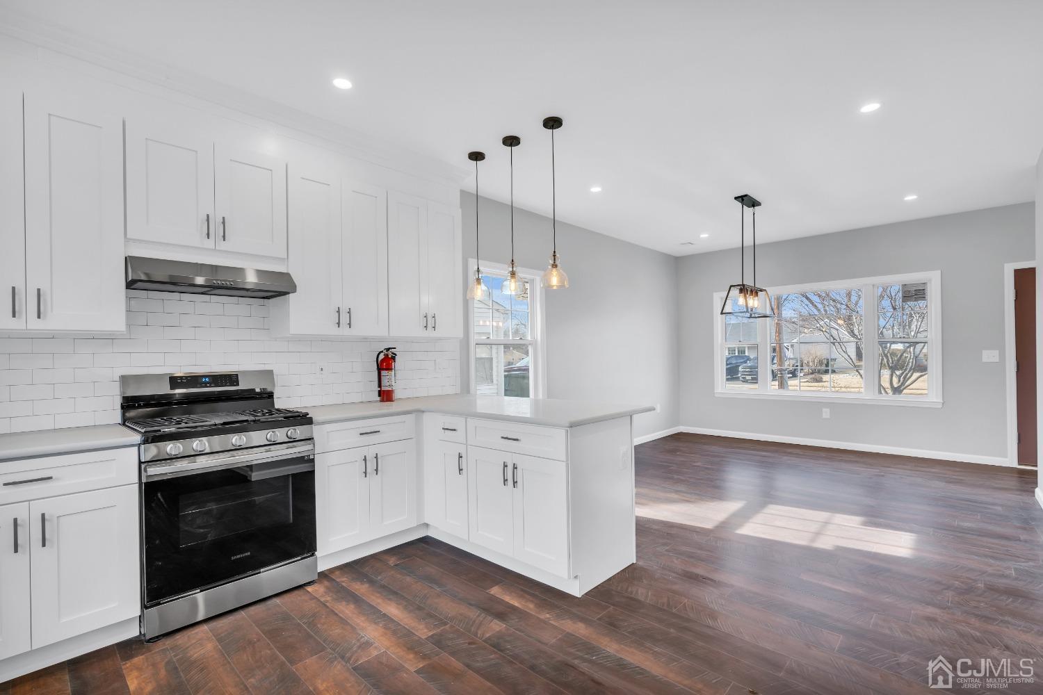 12 Fairfax Road Edison, NJ 08817 - Photo 11 of 30 a kitchen with stainless steel appliances white cabinets and wooden floor