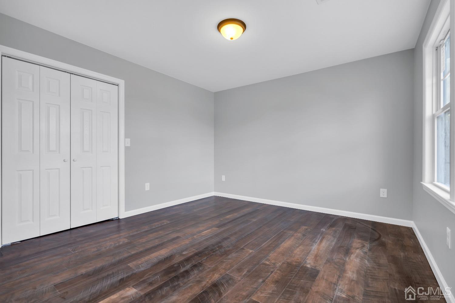 12 Fairfax Road Edison, NJ 08817 - Photo 18 of 30 a view of an empty room with window and wooden floor