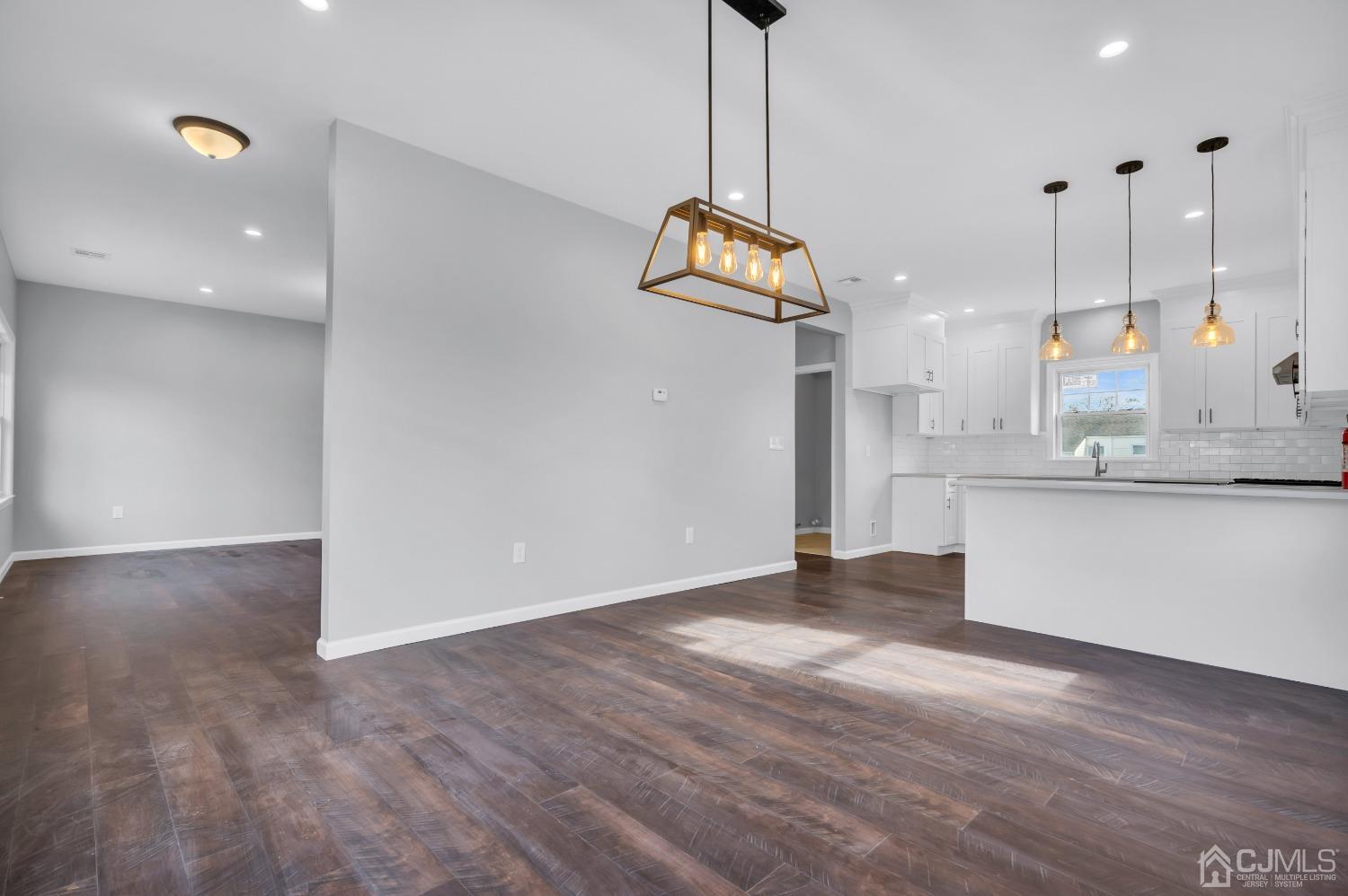 12 Fairfax Road Edison, NJ 08817 - Photo 8 of 30 a view of an empty room and kitchen with wooden floor