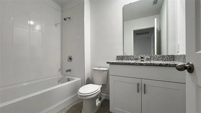 a bathroom with a sink toilet vanity and shower