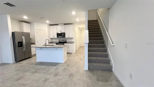 a kitchen with stainless steel appliances a refrigerator and a stove top oven