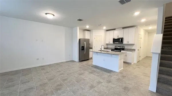 a kitchen with stainless steel appliances a refrigerator and a stove top oven