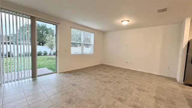 a view of an empty room with wooden floor and balcony