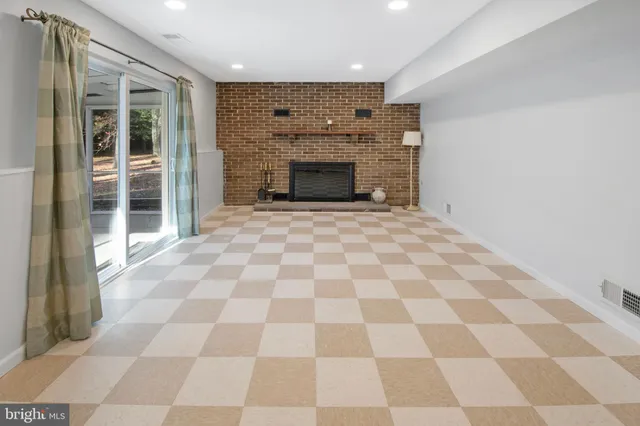 a large room with a checkered floor and a fireplace