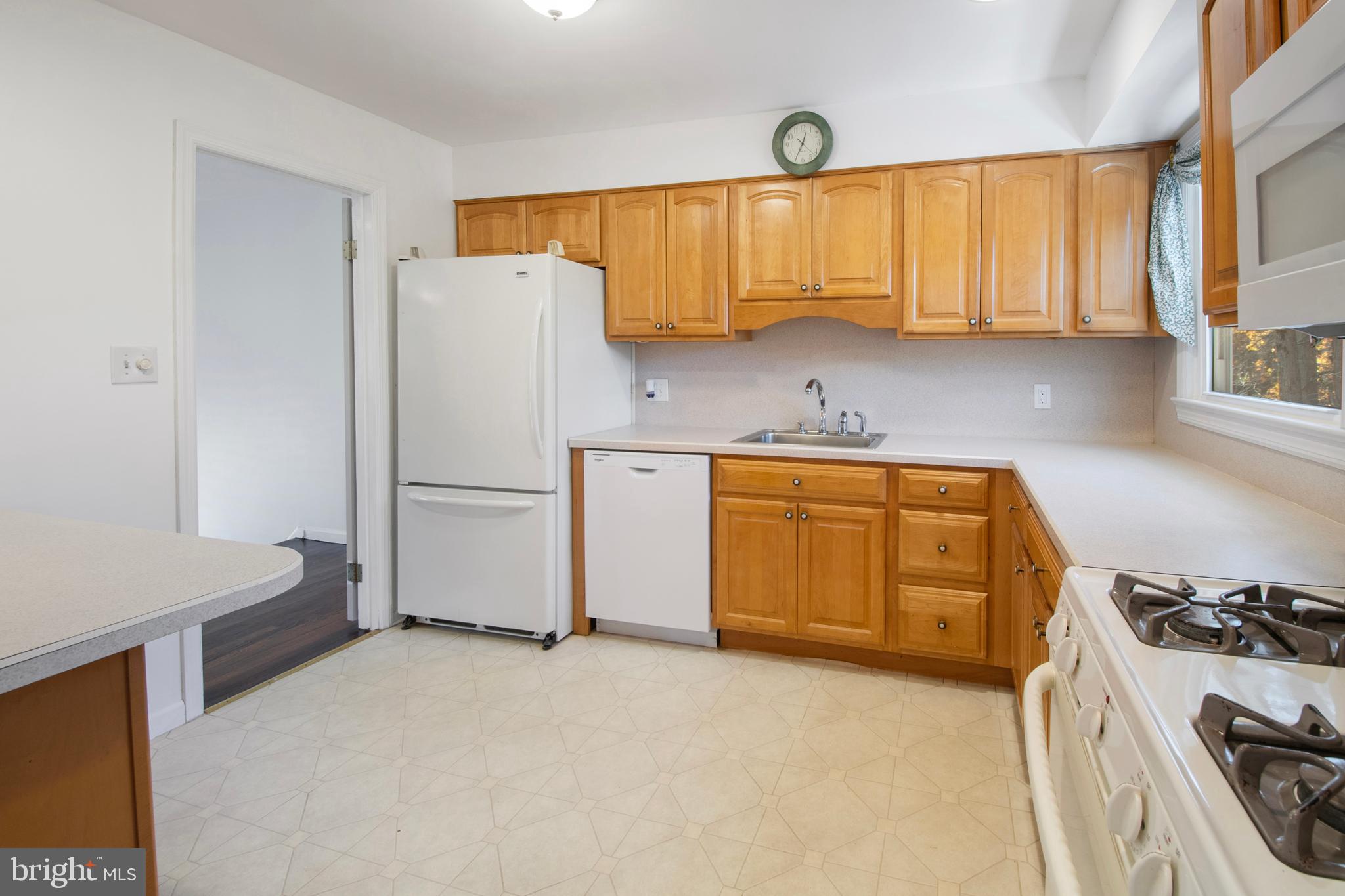 155 Franklin Corner Road Lawrence Township, NJ 08648 - Photo 9 of 29 a kitchen with a refrigerator a stove a sink dishwasher and wooden cabinets with wooden floor