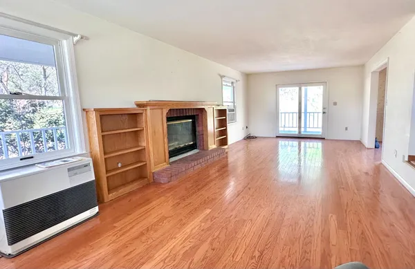a view of empty room with wooden floor and floor to ceiling window