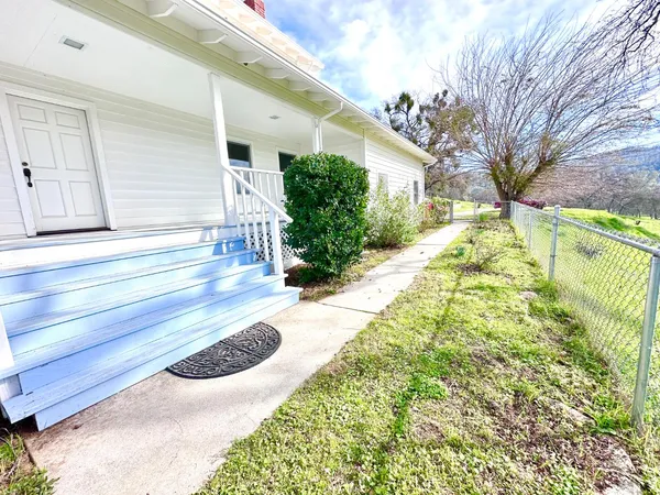 a view of a house with a yard and potted plants