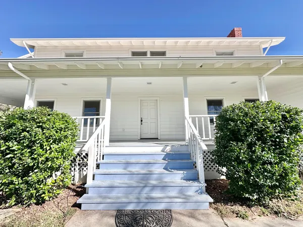 a front view of a house with plants