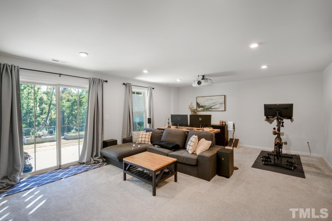 1027 Brownsmith Drive Apex, NC 27502 - Photo 12 of 21 a living room with furniture a large window and a flat screen tv