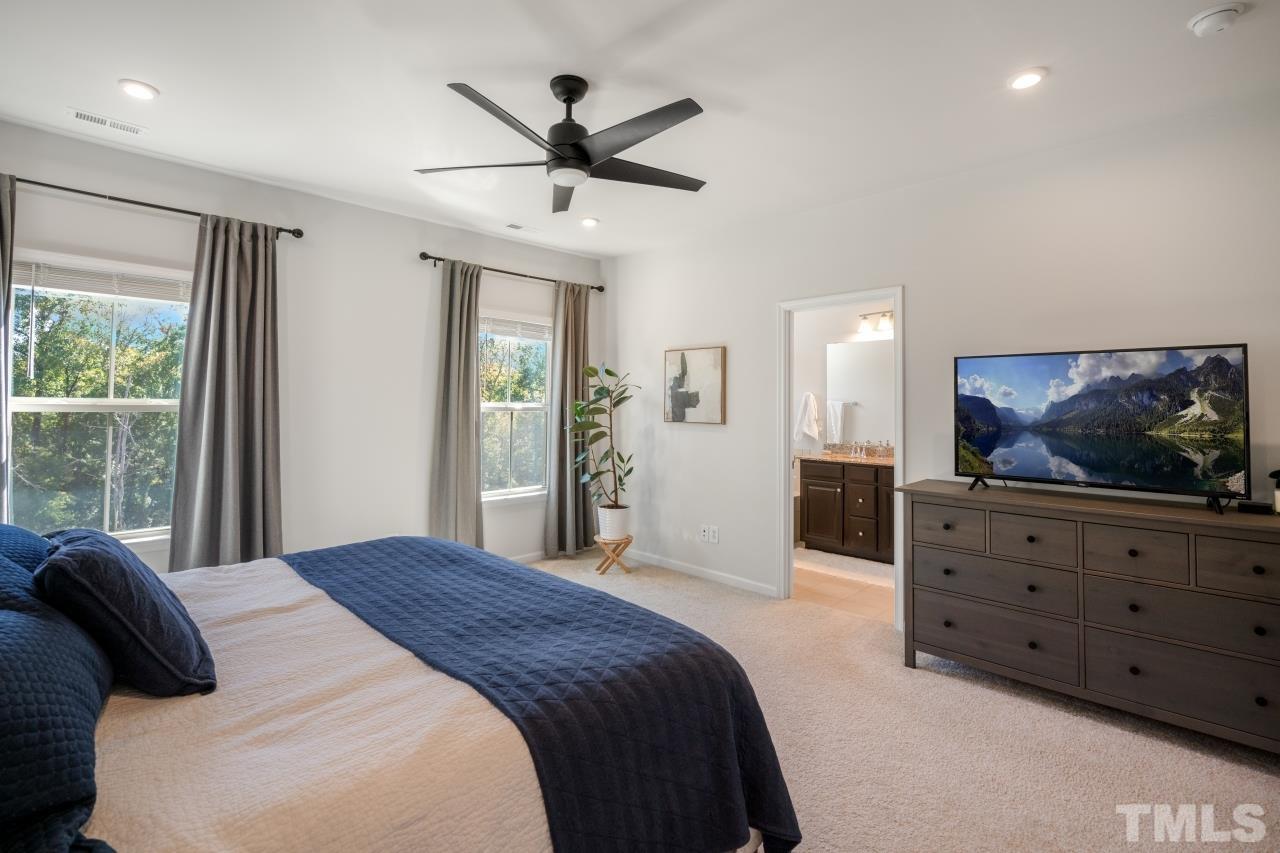 1027 Brownsmith Drive Apex, NC 27502 - Photo 16 of 21 a bedroom with a bed a window and a television