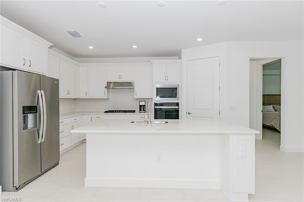 1954 Fresno Avenue Naples, FL 34120 - Photo 22 of 40 a kitchen with kitchen island a sink stainless steel appliances and cabinets