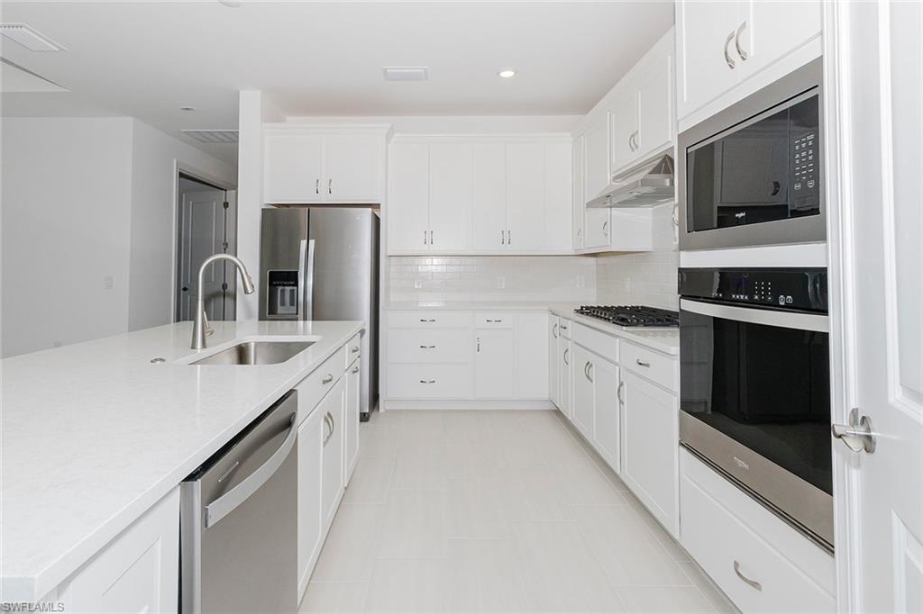 1954 Fresno Avenue Naples, FL 34120 - Photo 25 of 40 a kitchen with a sink stove and refrigerator