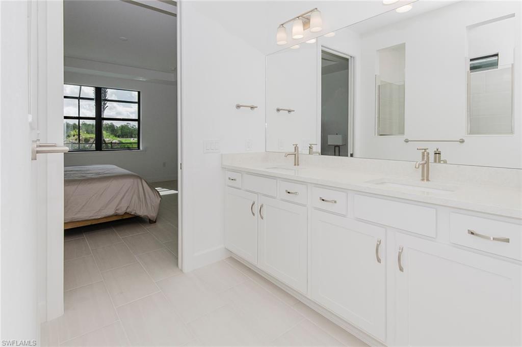 1954 Fresno Avenue Naples, FL 34120 - Photo 30 of 40 a en suite bathroom with a double vanity sink and mirror