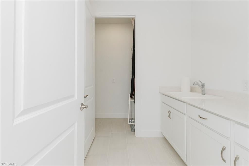 1954 Fresno Avenue Naples, FL 34120 - Photo 37 of 40 a bathroom with a sink and mirror