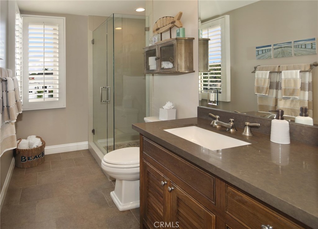 23711 Colima Bay Dana Point, CA 92629 - Photo 16 of 45 a bathroom with a granite countertop sink a toilet a mirror and shower