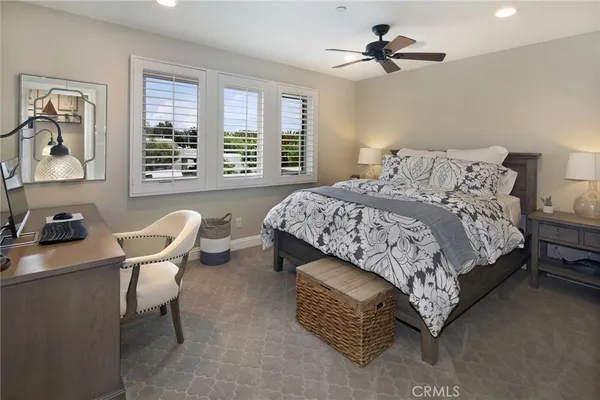 a bedroom with a bed and a dresser with wooden floor