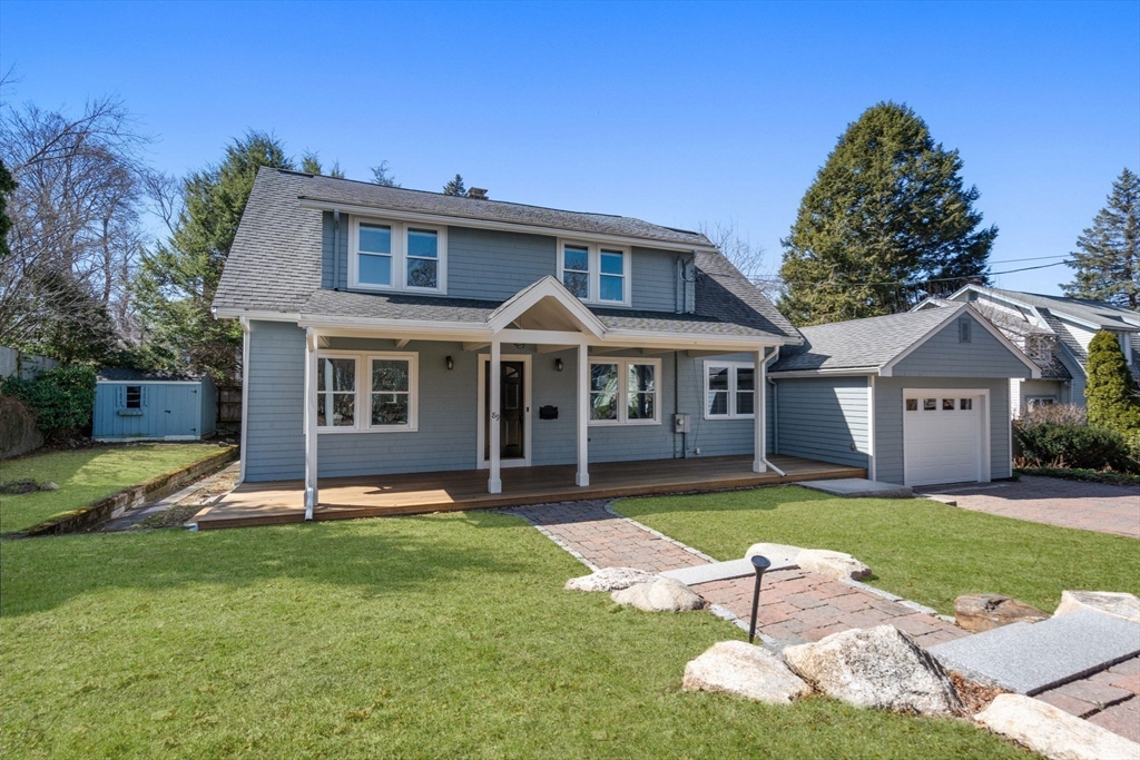 a front view of a house with a yard and trees