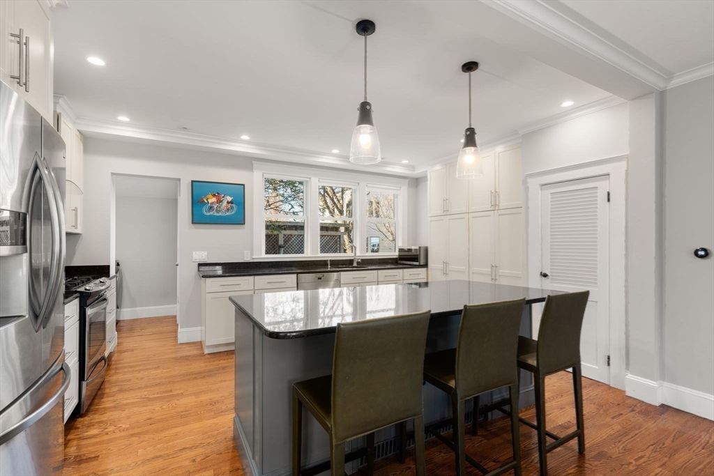 89 Prospect Street Newton, MA 02465 - Photo 12 of 31 a kitchen with stainless steel appliances granite countertop a stove a refrigerator a oven a sink with a dining table and chairs