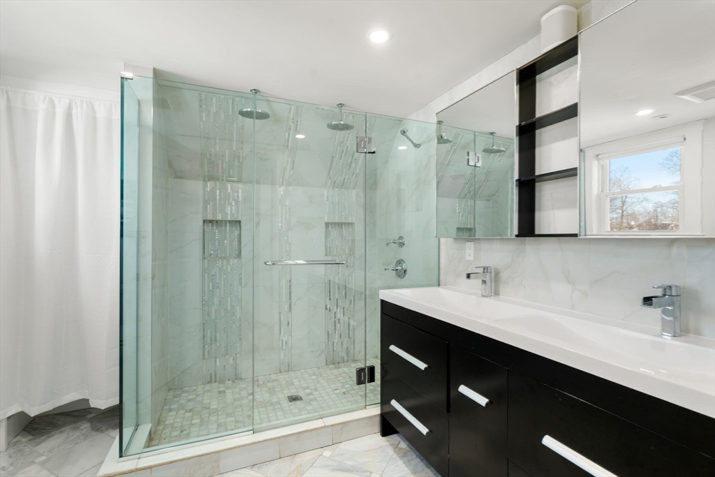 89 Prospect Street Newton, MA 02465 - Photo 22 of 31 a bathroom with a shower sink and mirror