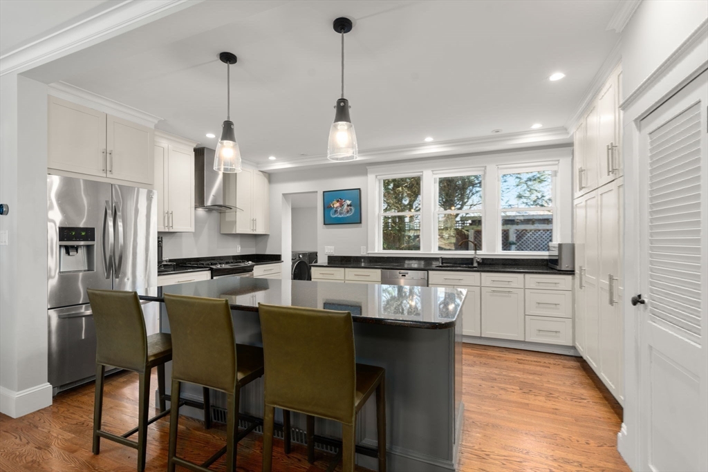 89 Prospect Street Newton, MA 02465 - Photo 10 of 31 a kitchen with stainless steel appliances granite countertop a kitchen island a stove a table and chairs in it