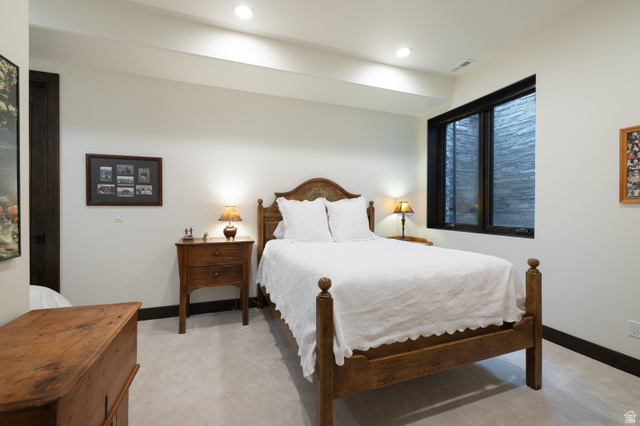 11547 Soaring Hawk Lane Hideout, UT 84036 - Photo 17 of 43 Carpeted bedroom featuring a dark wood door, recessed lighting, and a window with a stone-textured exterior