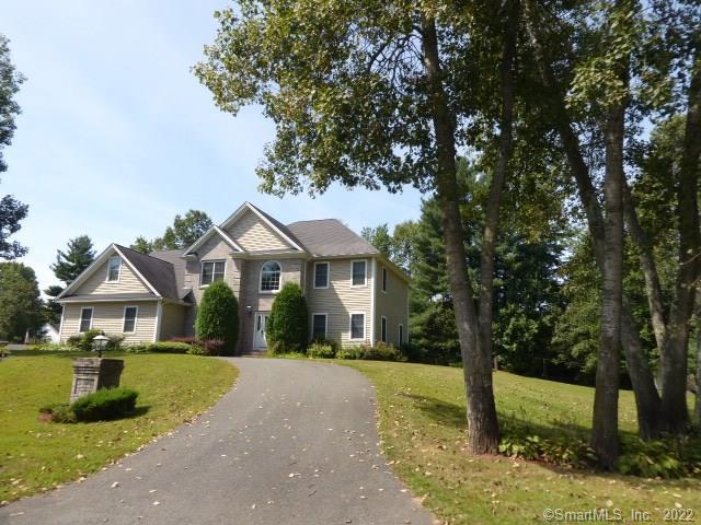 a front view of a house with a garden and yard