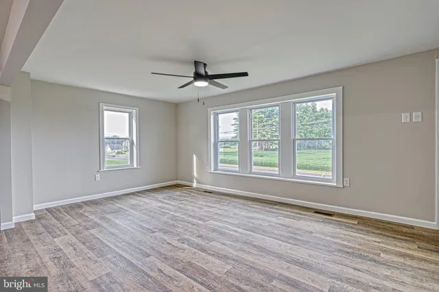 a view of a kitchen with wooden floor and a window