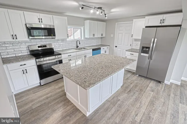 a kitchen with granite countertop a sink and a stove top oven