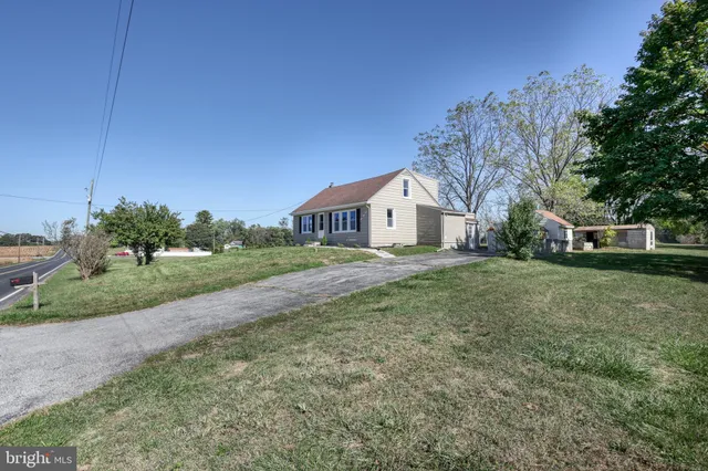 a view of a house with a yard and pathway