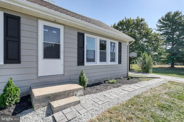 a kitchen with kitchen island granite countertop a stove top oven a sink dishwasher a dining table and chairs with wooden floor