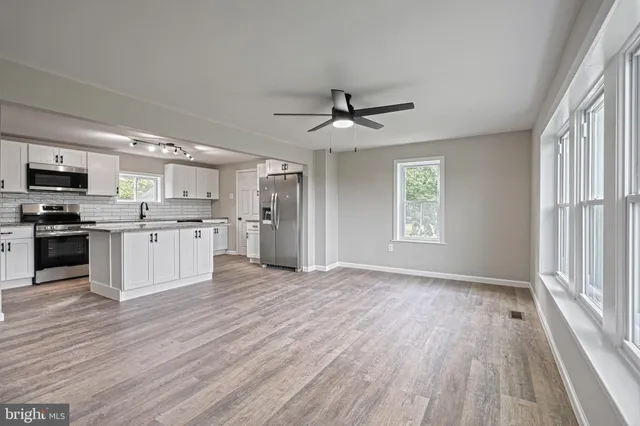 a kitchen with stainless steel appliances granite countertop a refrigerator a stove top oven a sink and dishwasher