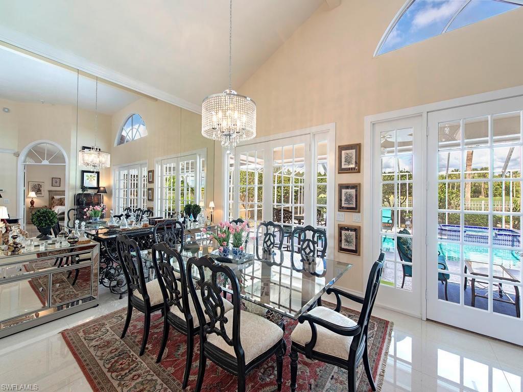 203 Via Napoli Naples, FL 34105 - Photo 4 of 13 a view of a dining room with furniture wooden floor and chandelier