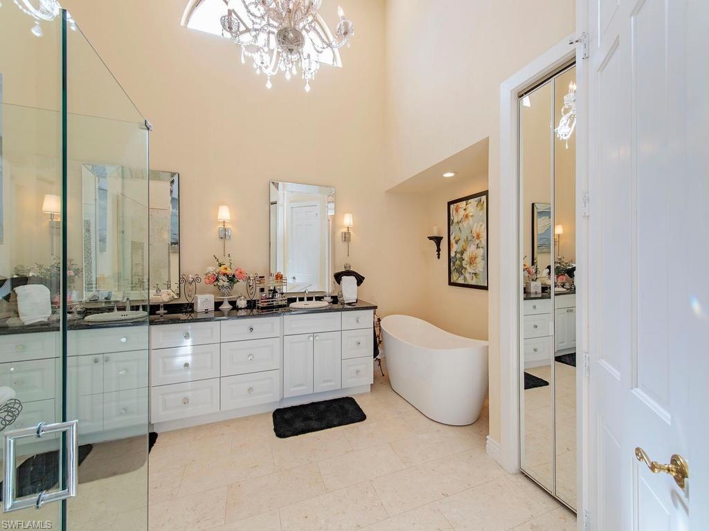 203 Via Napoli Naples, FL 34105 - Photo 7 of 13 a large bathroom with a double vanity sink a mirror and a bathtub