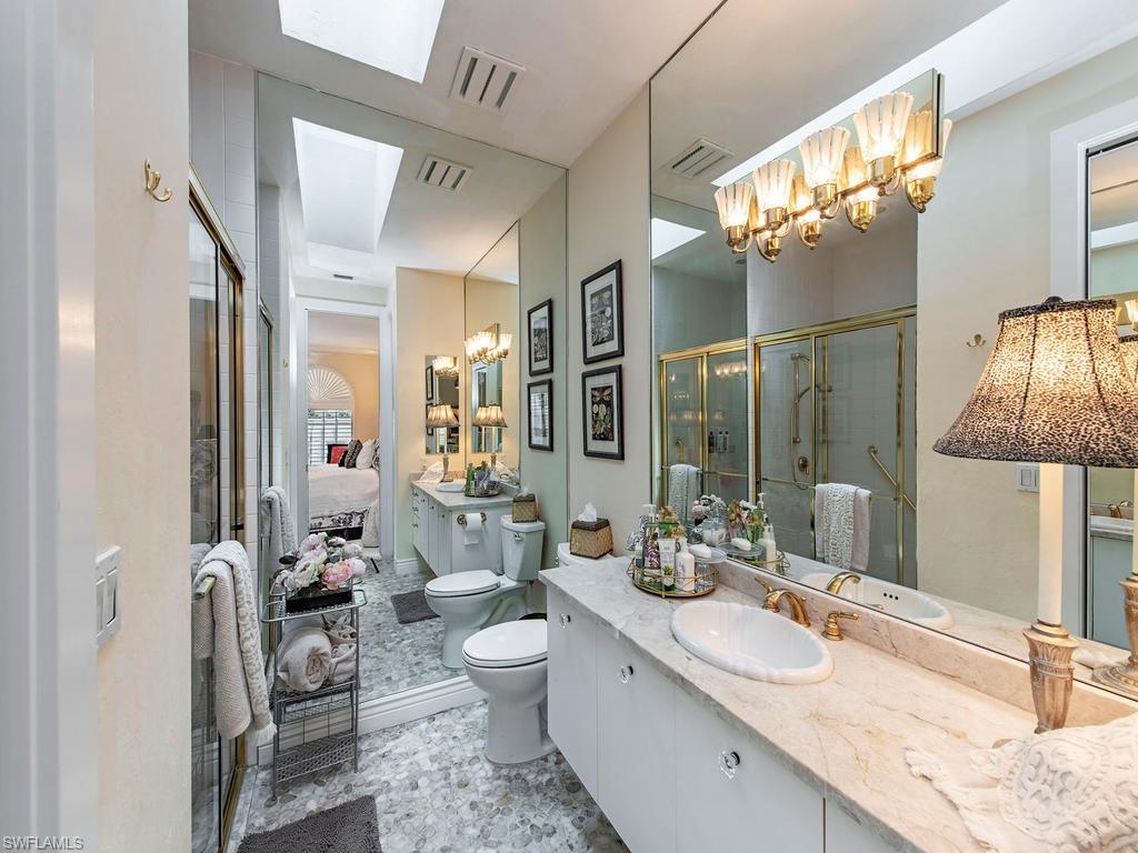 203 Via Napoli Naples, FL 34105 - Photo 9 of 13 a spacious bathroom with a granite countertop sink and a mirror