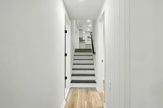 a view of a hallway with stairs and wooden floor