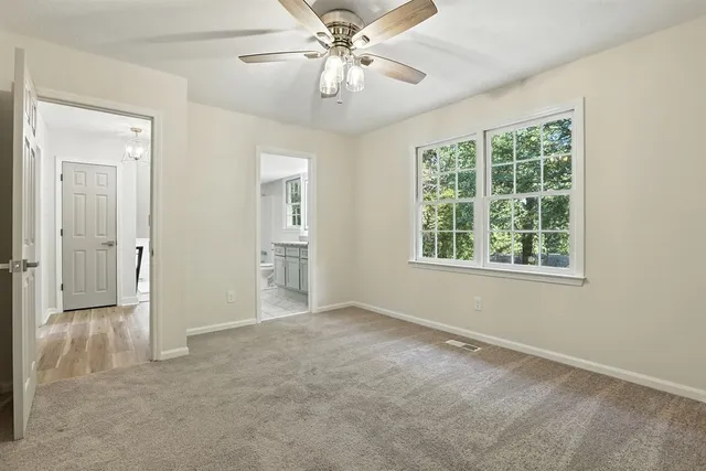 an empty room with fan and windows