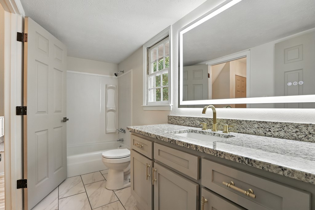4627 Wimbish Court Columbus, GA 31909 - Photo 23 of 33 a bathroom with a granite countertop sink a mirror and a toilet