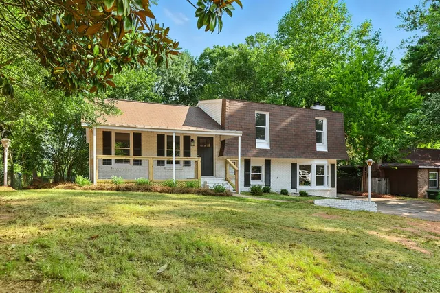 a front view of a house with a garden