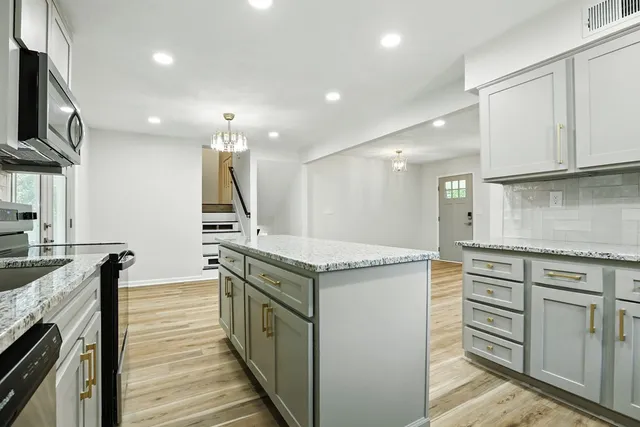 a kitchen with granite countertop cabinets stainless steel appliances and a counter space