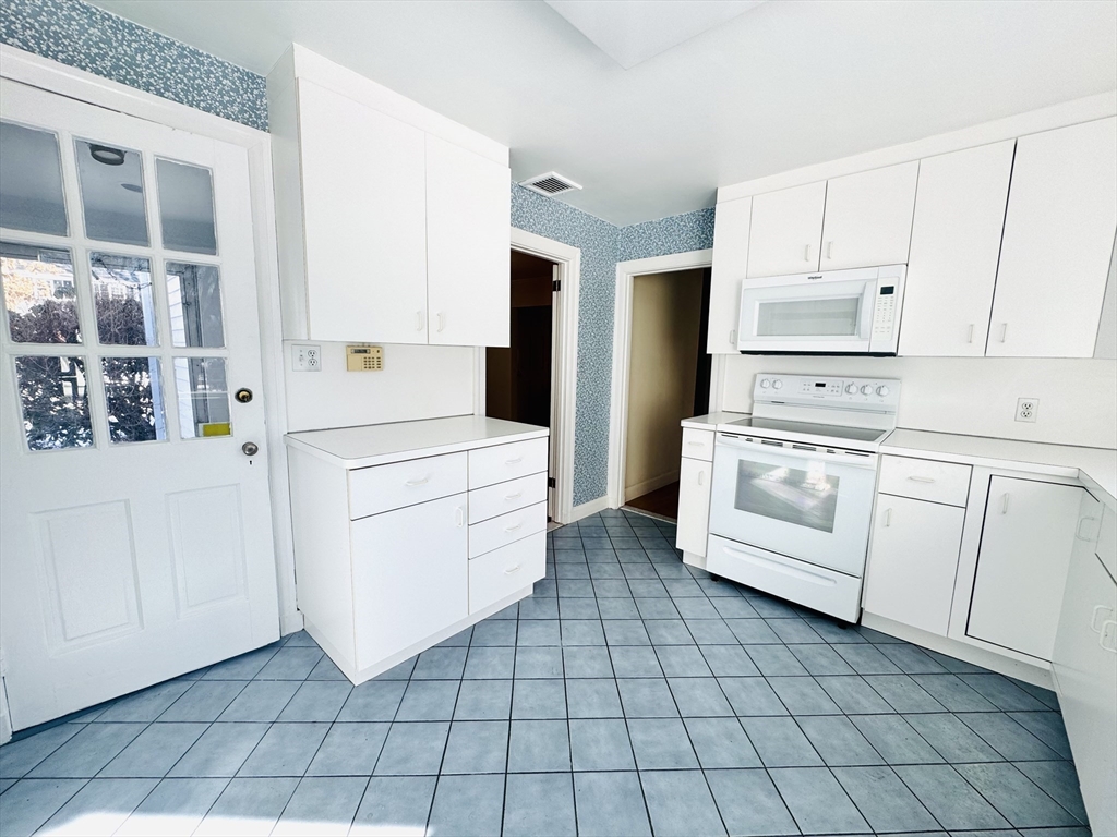 45 Beverly Road Brookline, MA 02467 - Photo 11 of 42 a kitchen with white cabinets and white appliances