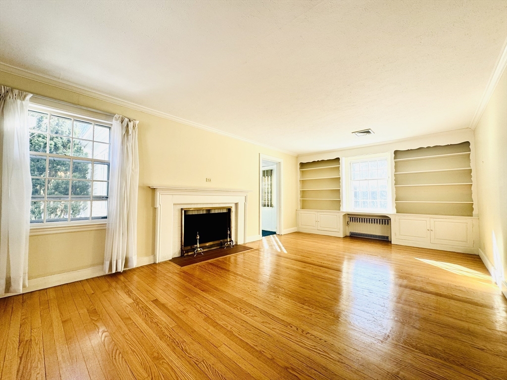 45 Beverly Road Brookline, MA 02467 - Photo 3 of 42 a view of empty room with a fireplace and wooden floor