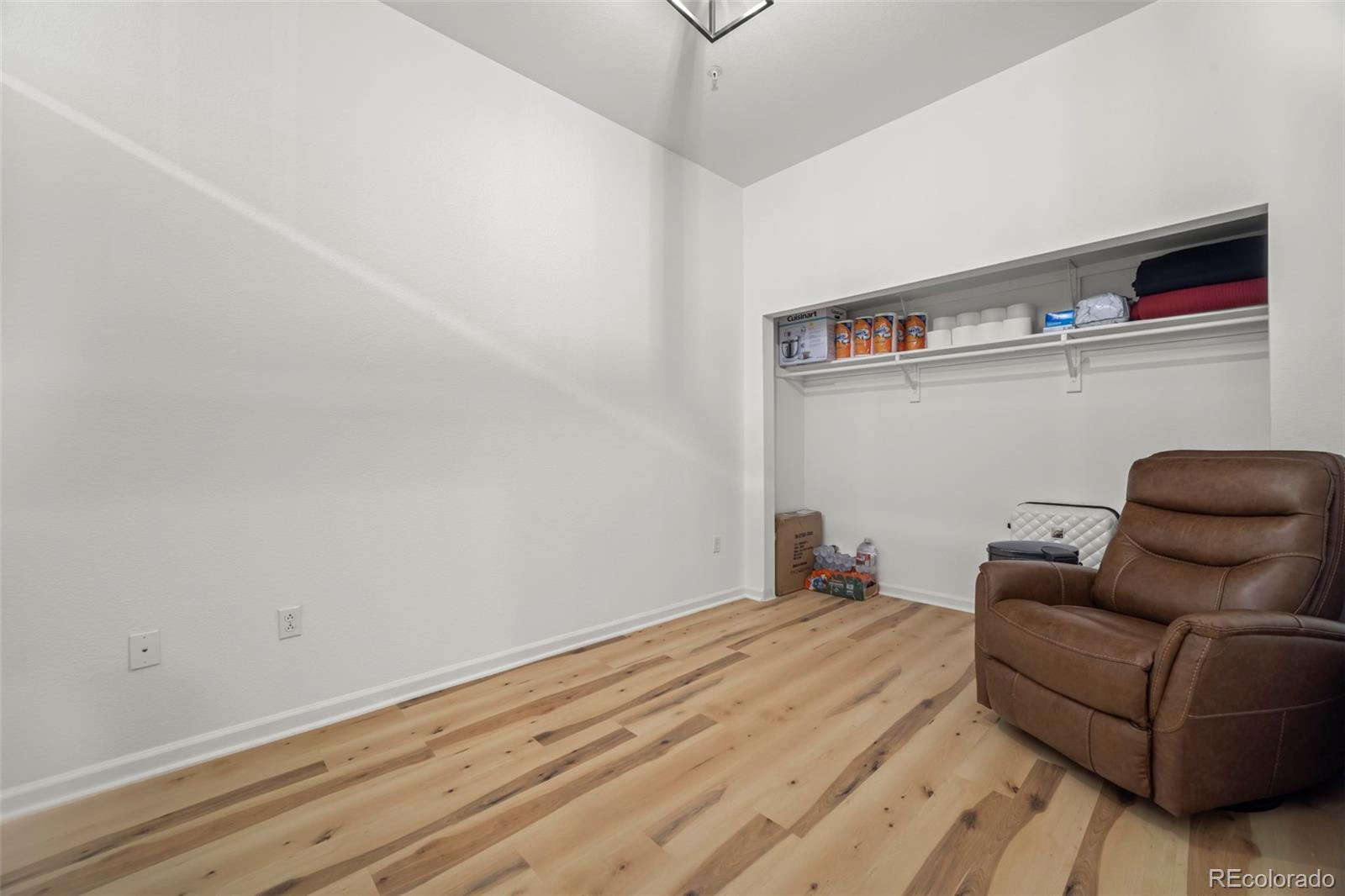 15475 Andrews Drive, Unit 307 Denver, CO 80239 - Photo 22 of 36 a room with a couch and a wooden floor