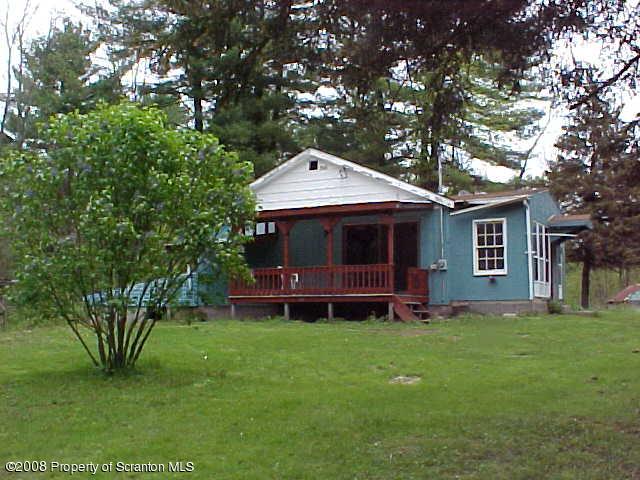 a front view of a house with a garden and trees