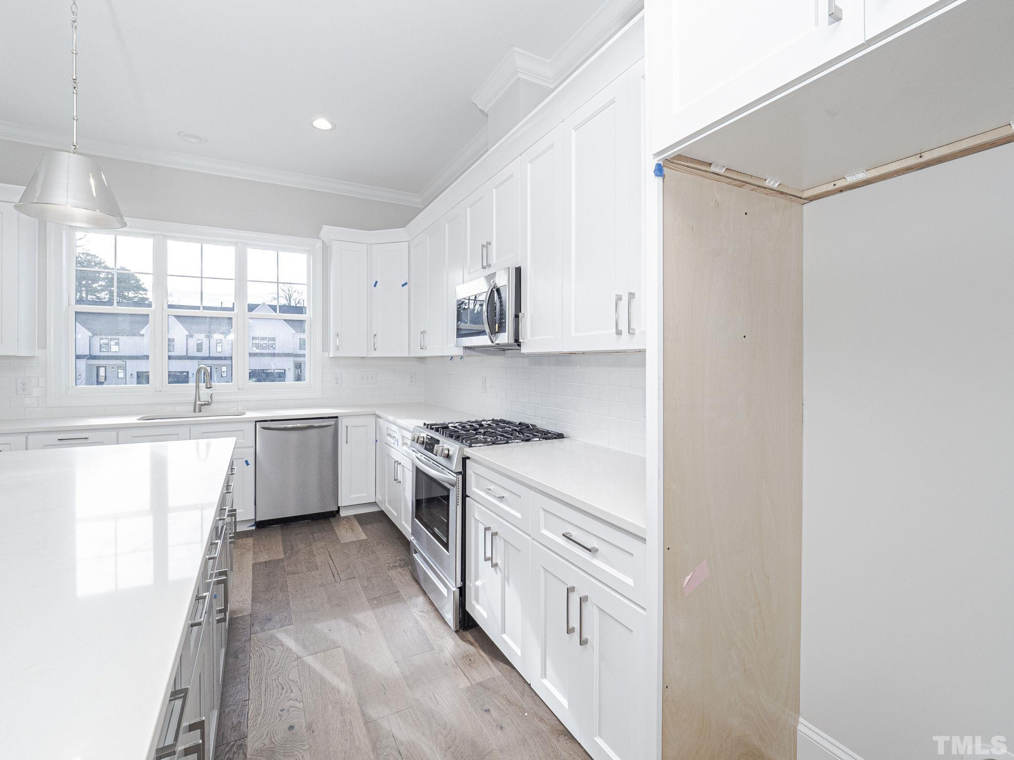 4922 Trek Lane Raleigh, NC 27606 - Photo 12 of 28 a kitchen with stainless steel appliances a white cabinets and sink