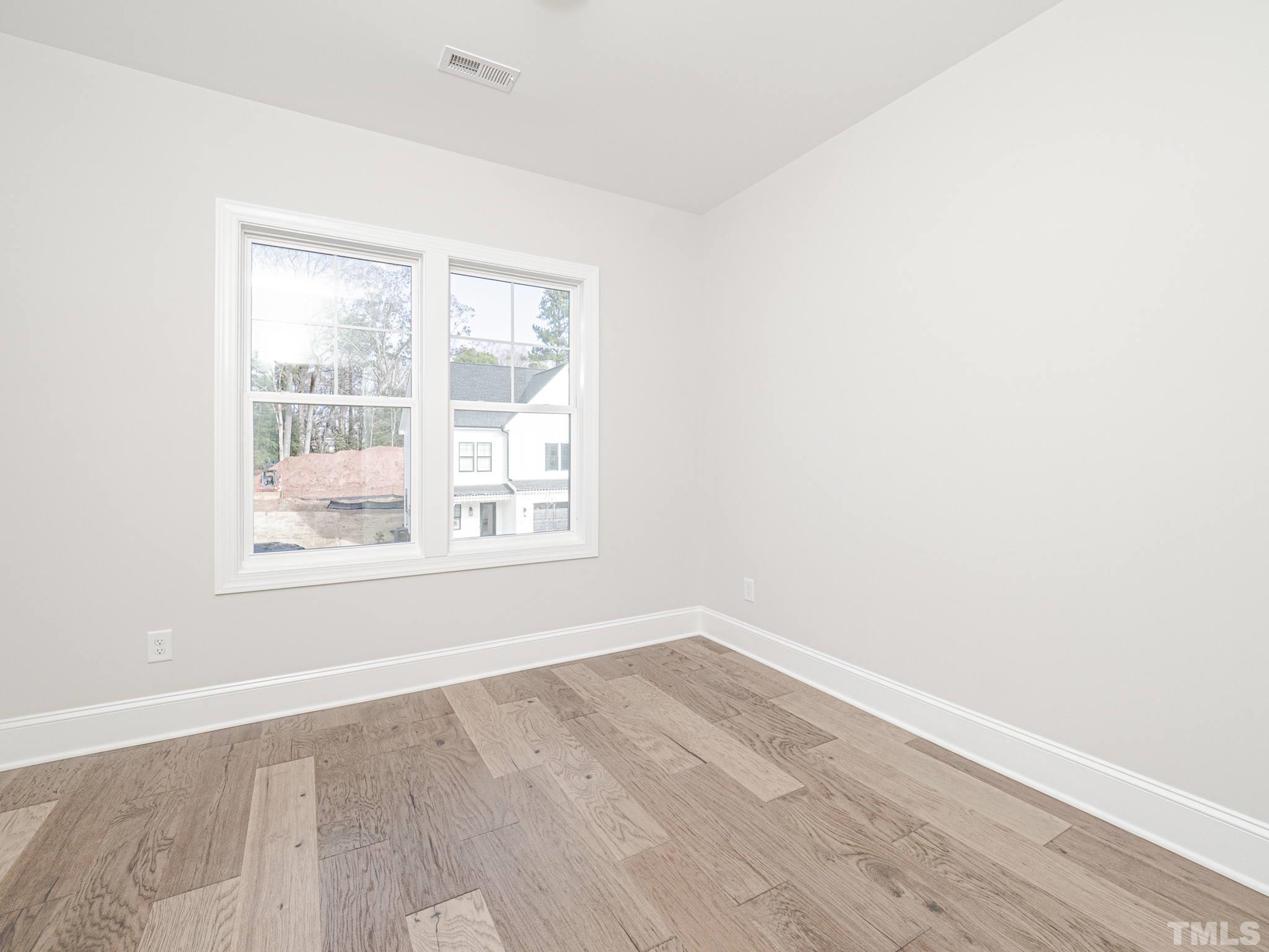 4922 Trek Lane Raleigh, NC 27606 - Photo 16 of 28 an empty room with wooden floor and windows