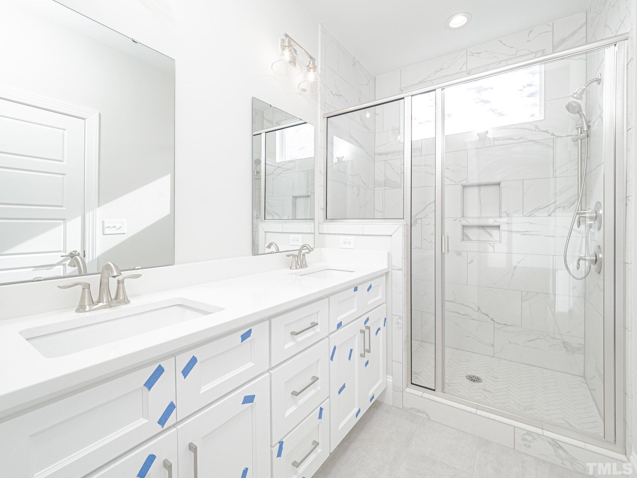 4922 Trek Lane Raleigh, NC 27606 - Photo 23 of 28 a bathroom with a double vanity sink mirror and shower