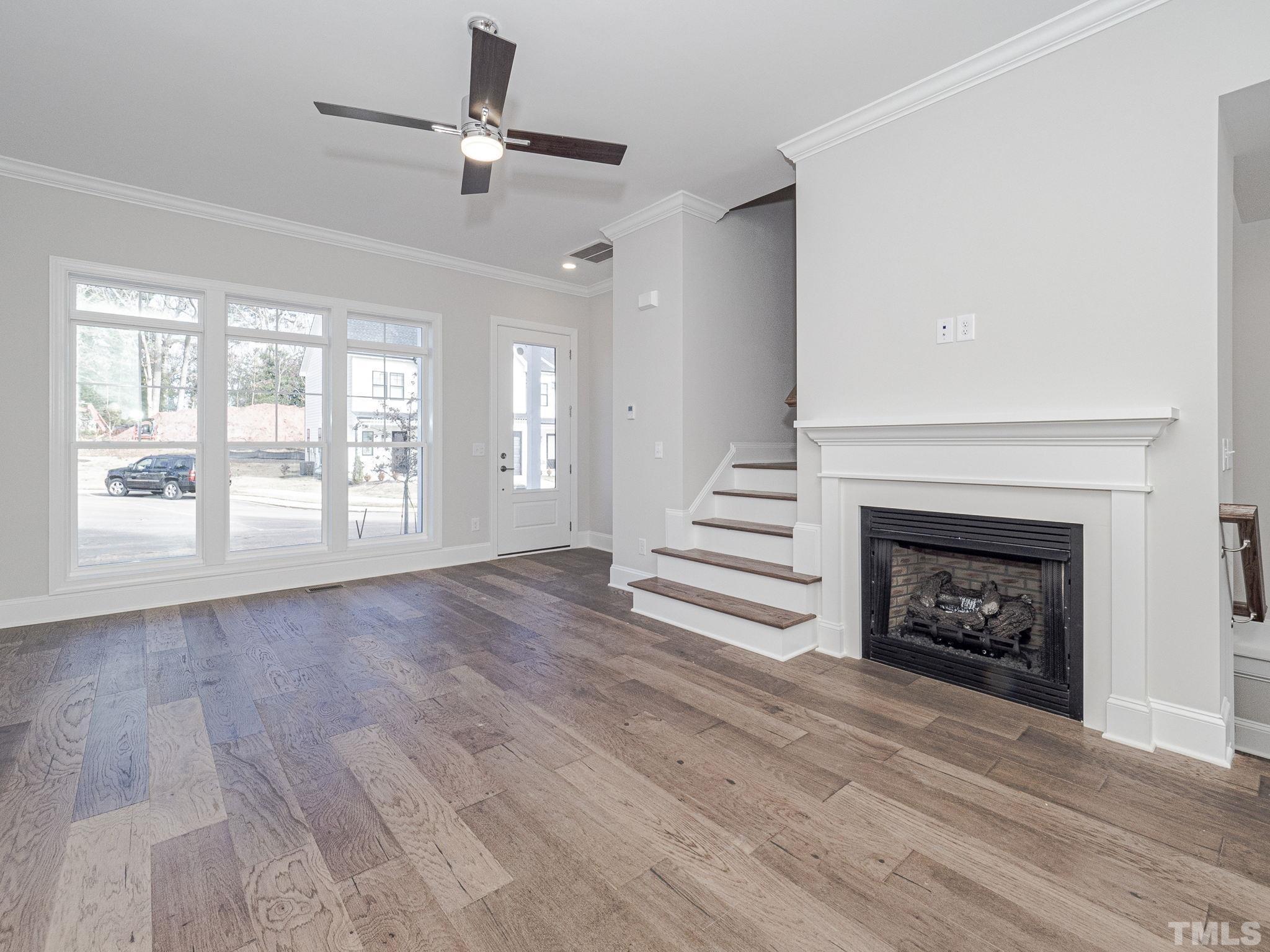 4922 Trek Lane Raleigh, NC 27606 - Photo 8 of 28 a view of an empty room with wooden floor fireplace and a window