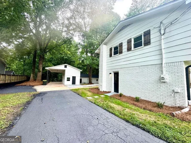 a front view of a house with a yard and trees
